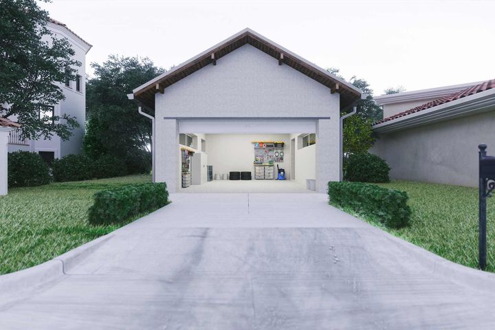 A white garage with the door open and a mailbox in front of it.
