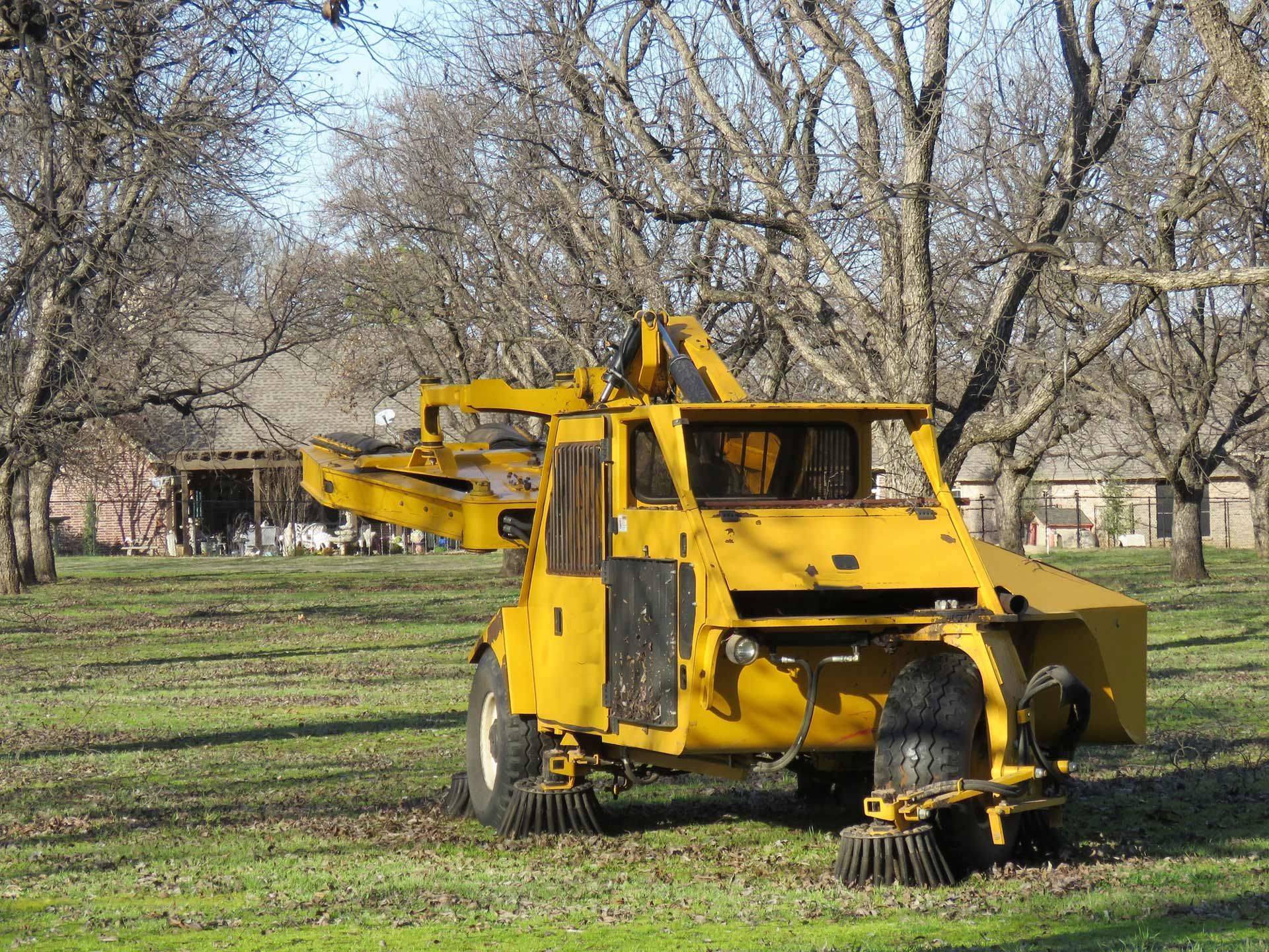 A yellow tractor is parked in a grassy field