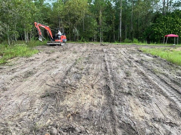 An excavator is moving dirt on a dirt road.