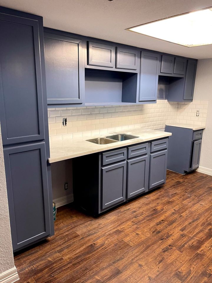 a kitchen with blue cabinets and a sink .