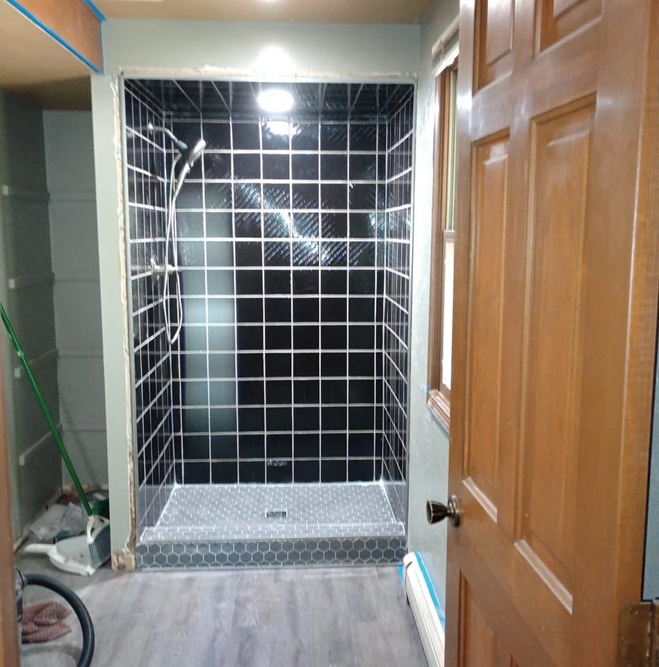 A bathroom with a walk in shower and a wooden door