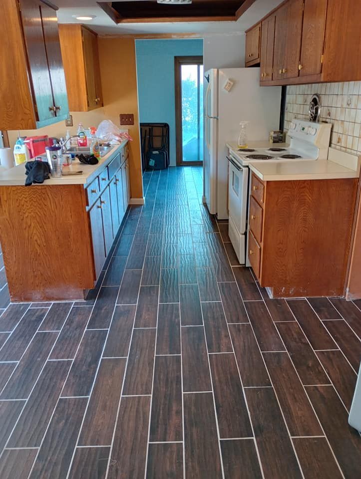 A kitchen with wooden cabinets and a tiled floor