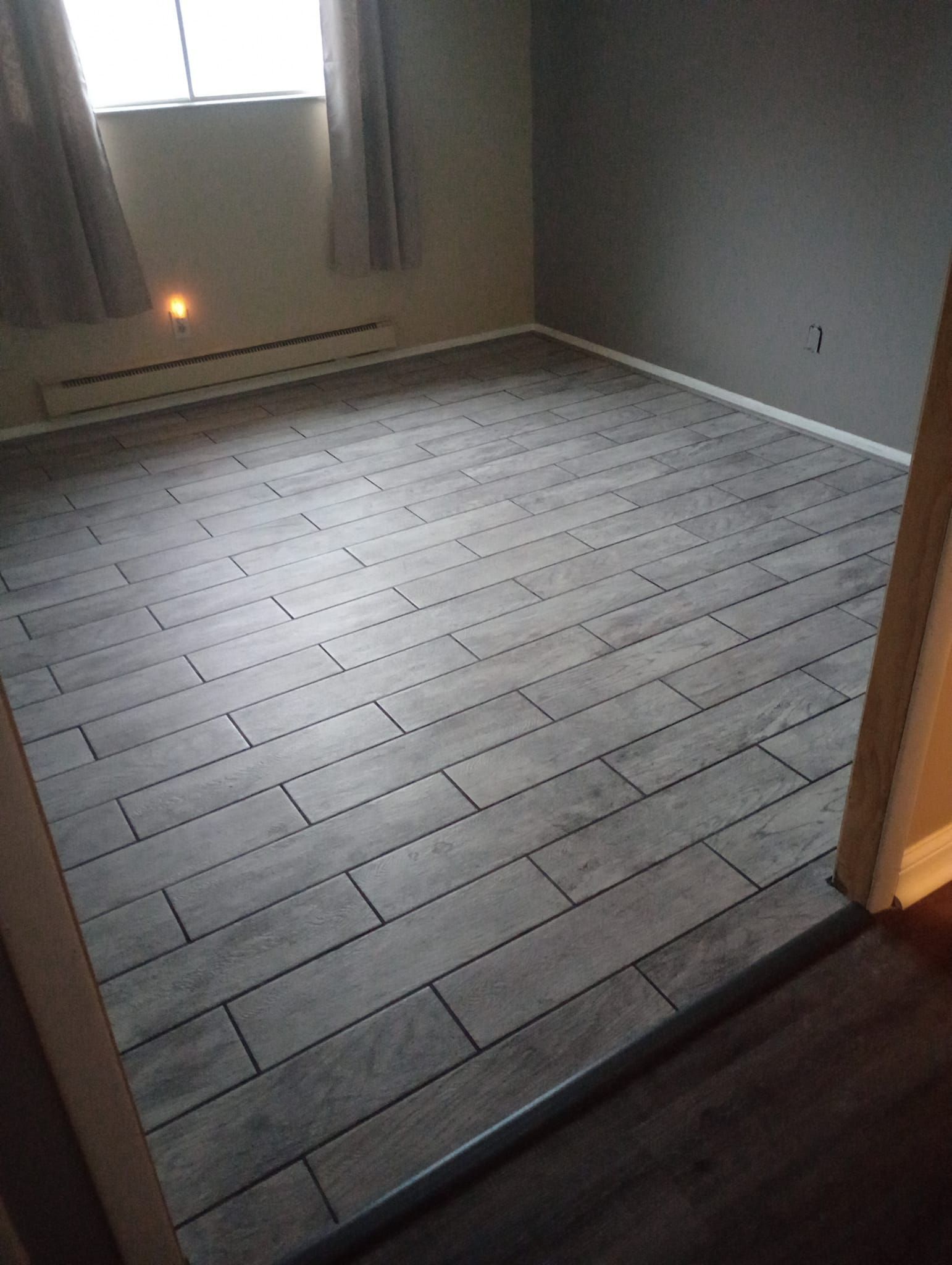 A room with a wooden floor and a window.
