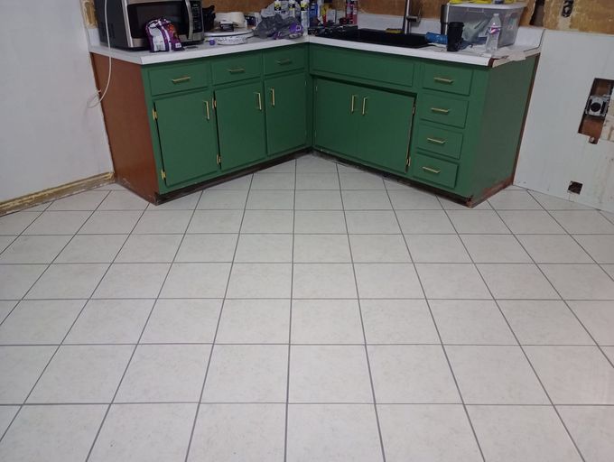 A kitchen with wooden cabinets and a tiled floor