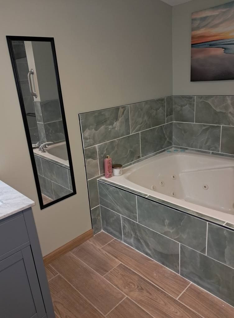 A bathroom with a jacuzzi tub and a mirror.
