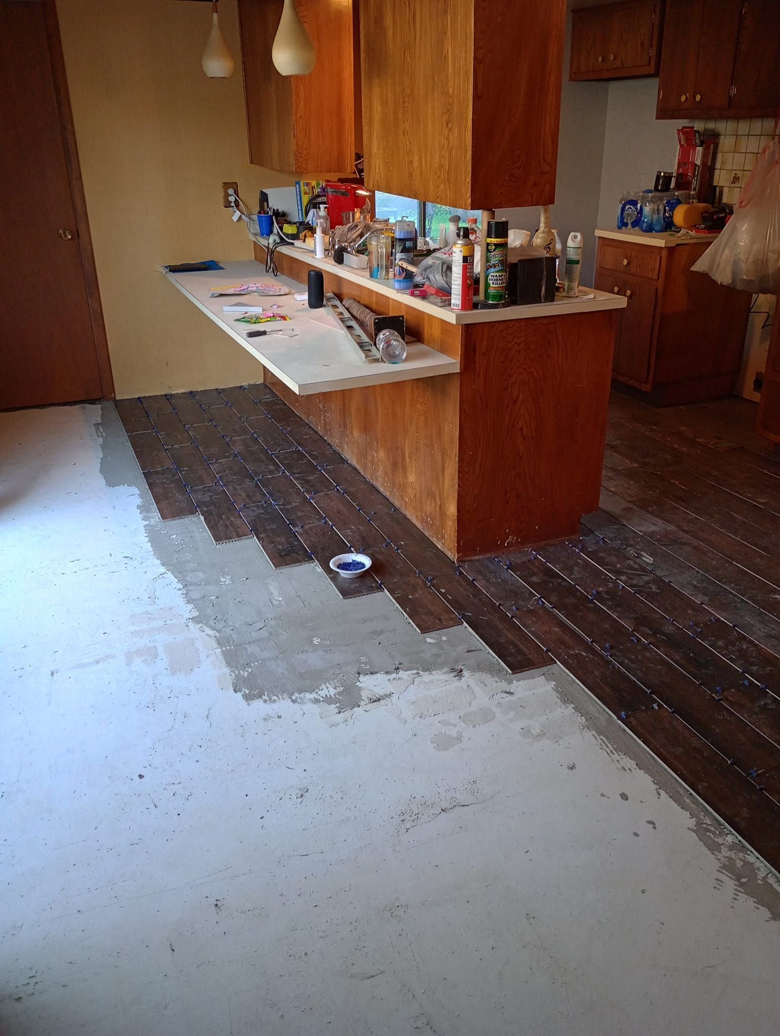 A kitchen with wooden cabinets and a white floor is being remodeled.
