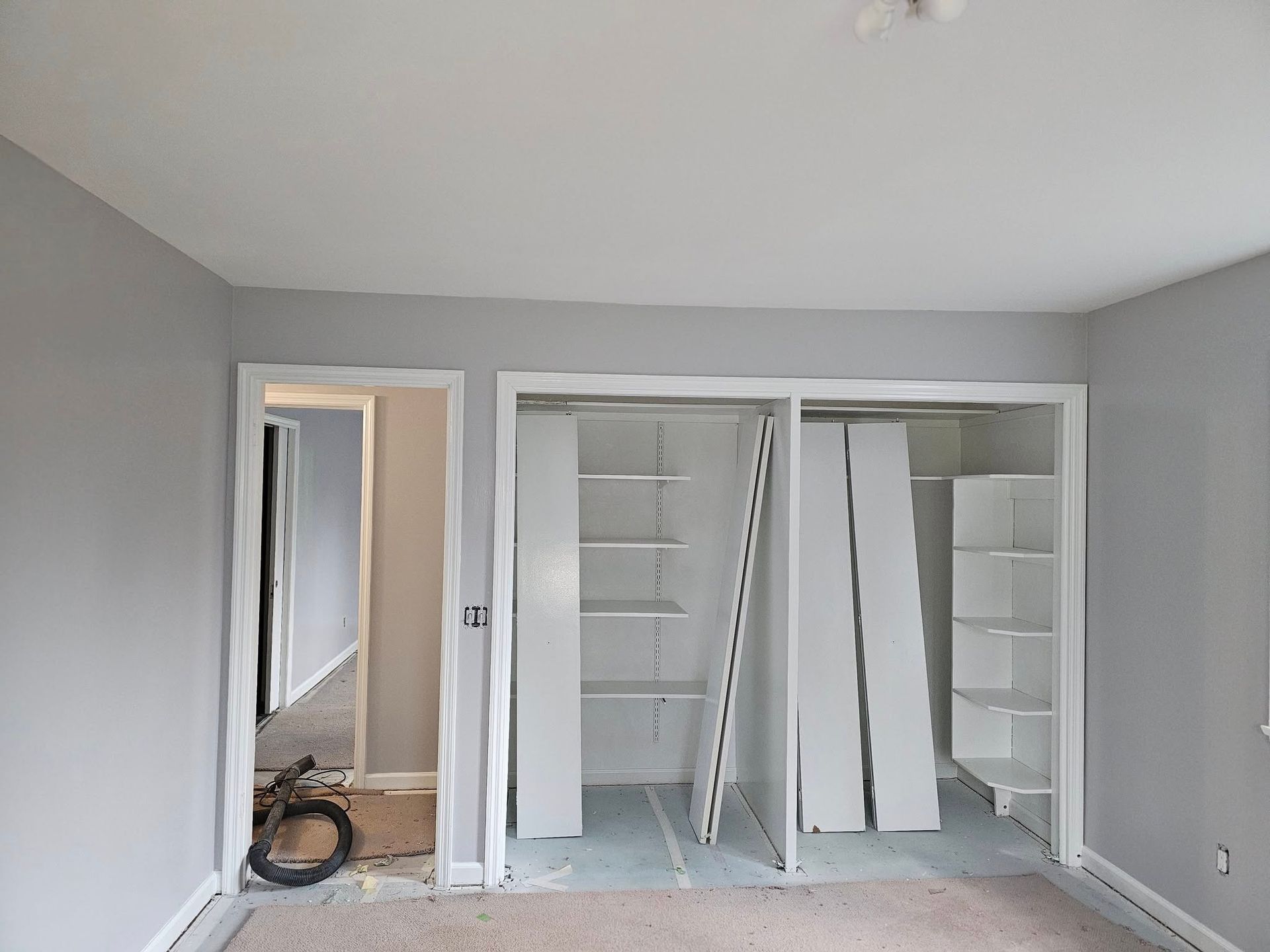 A room with a lot of shelves and a door that is open.