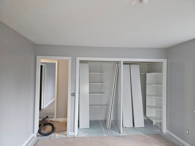 A room with a lot of shelves and a door that is open.