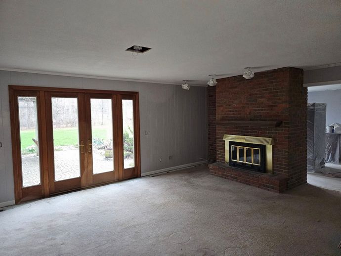 An empty living room with a fireplace and sliding glass doors