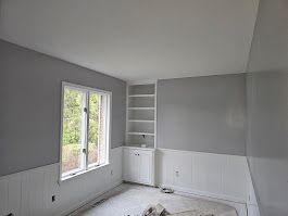 An empty room with stairs and a skylight in the ceiling.