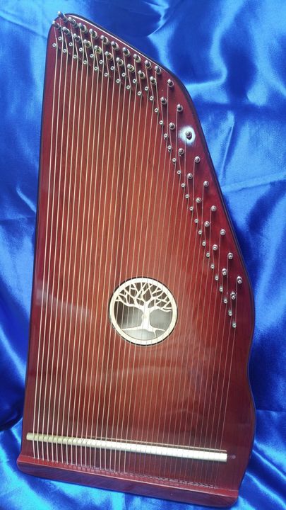 A harp with a tree on it is sitting on a blue cloth