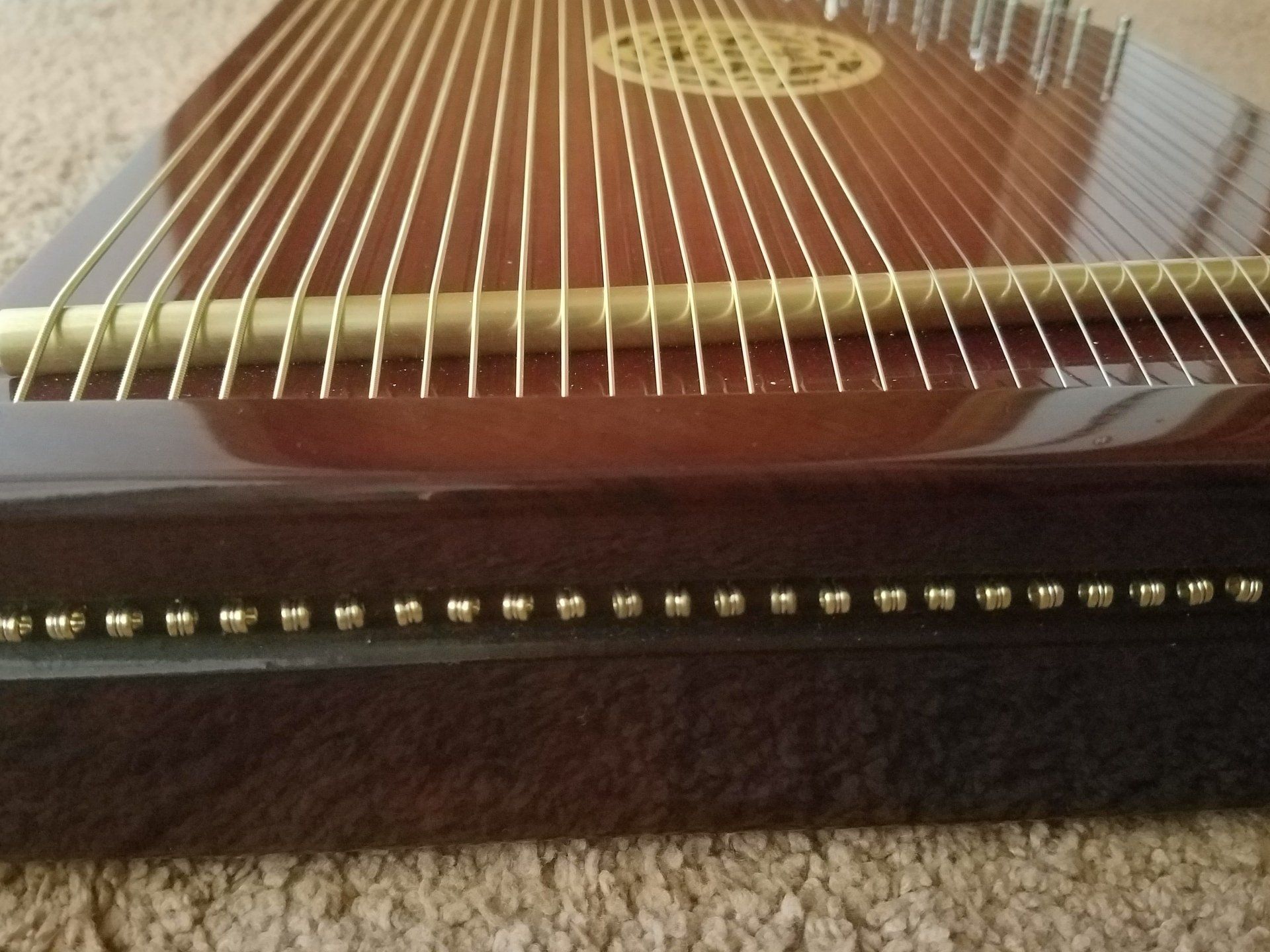 A harp is sitting on a carpeted floor