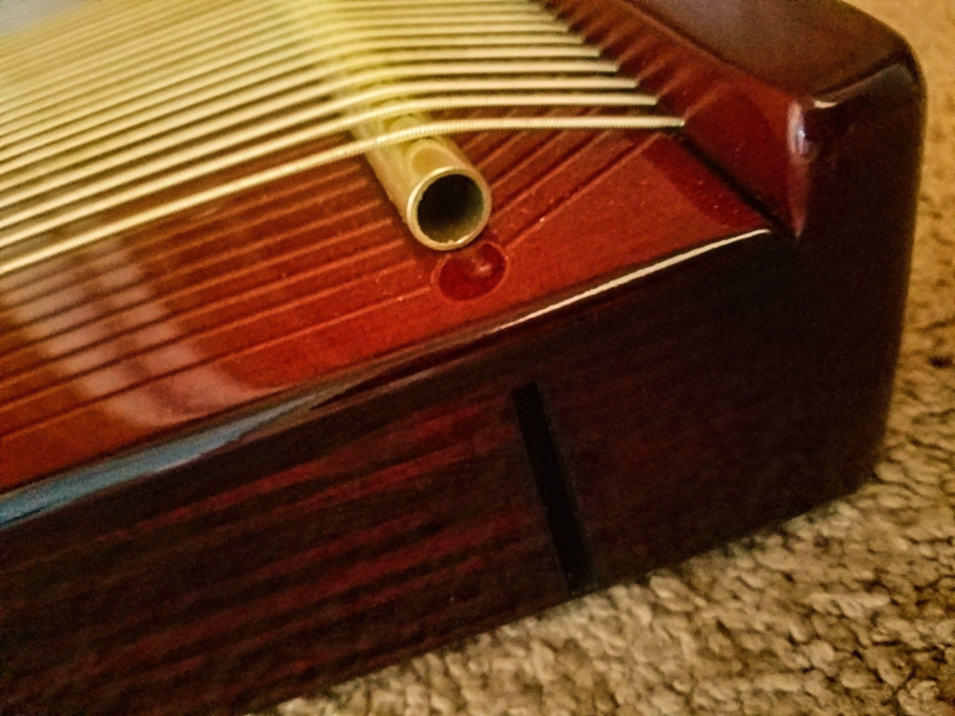 A close up of a musical instrument on a carpet.