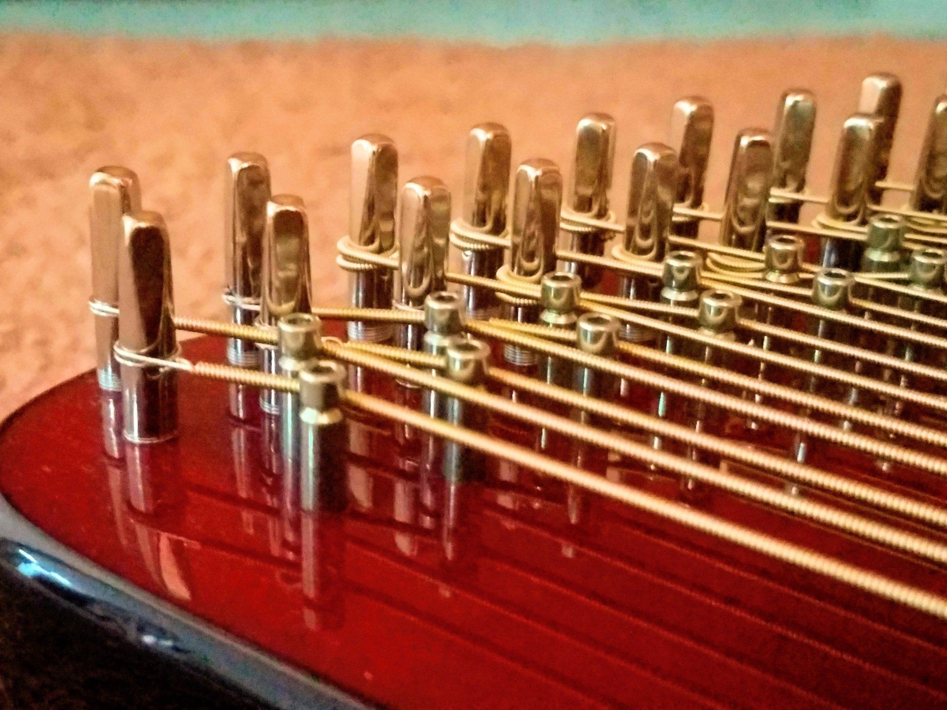 A close up of a musical instrument with a red top