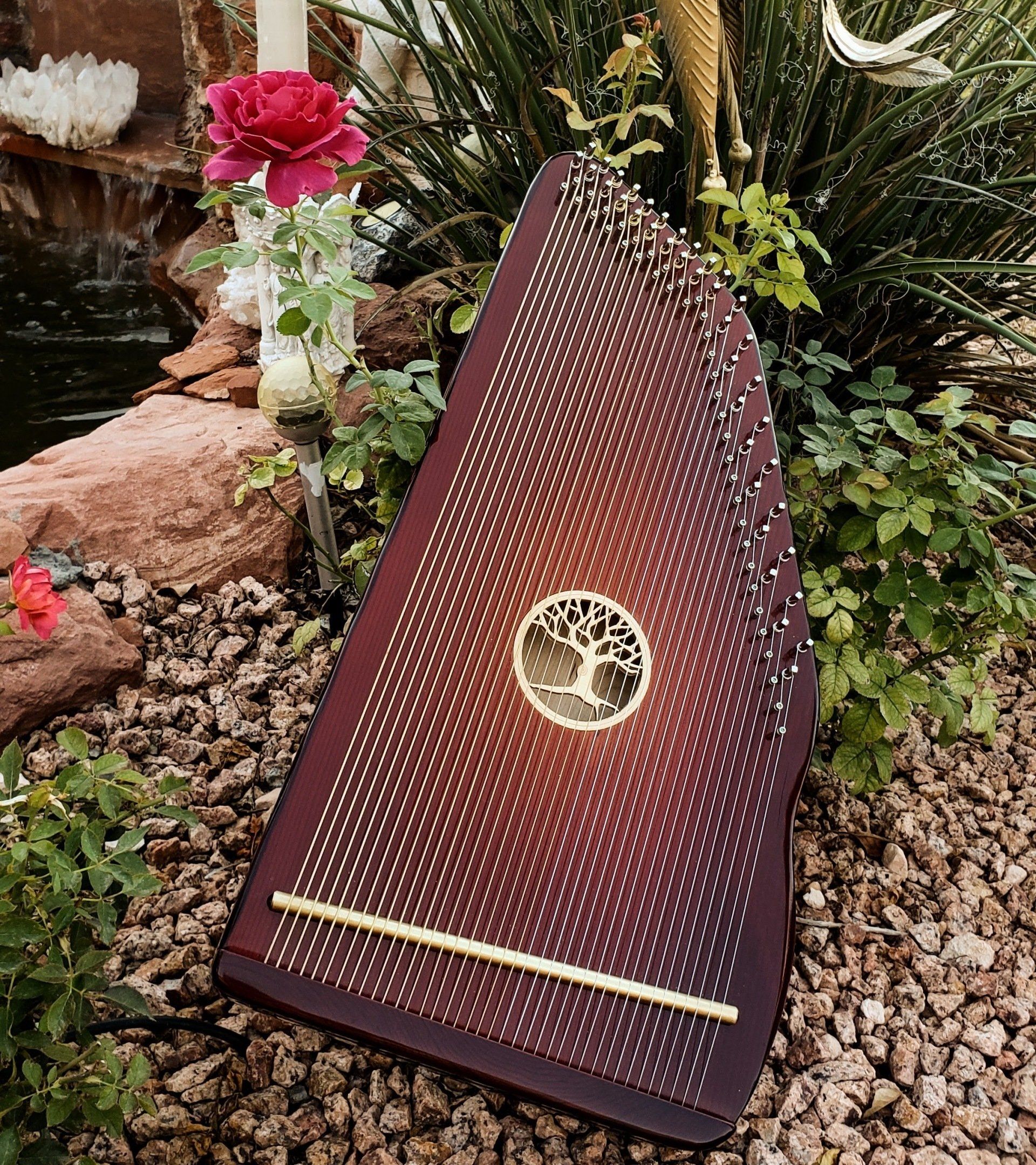 A harp is sitting on top of a pile of gravel in a garden.