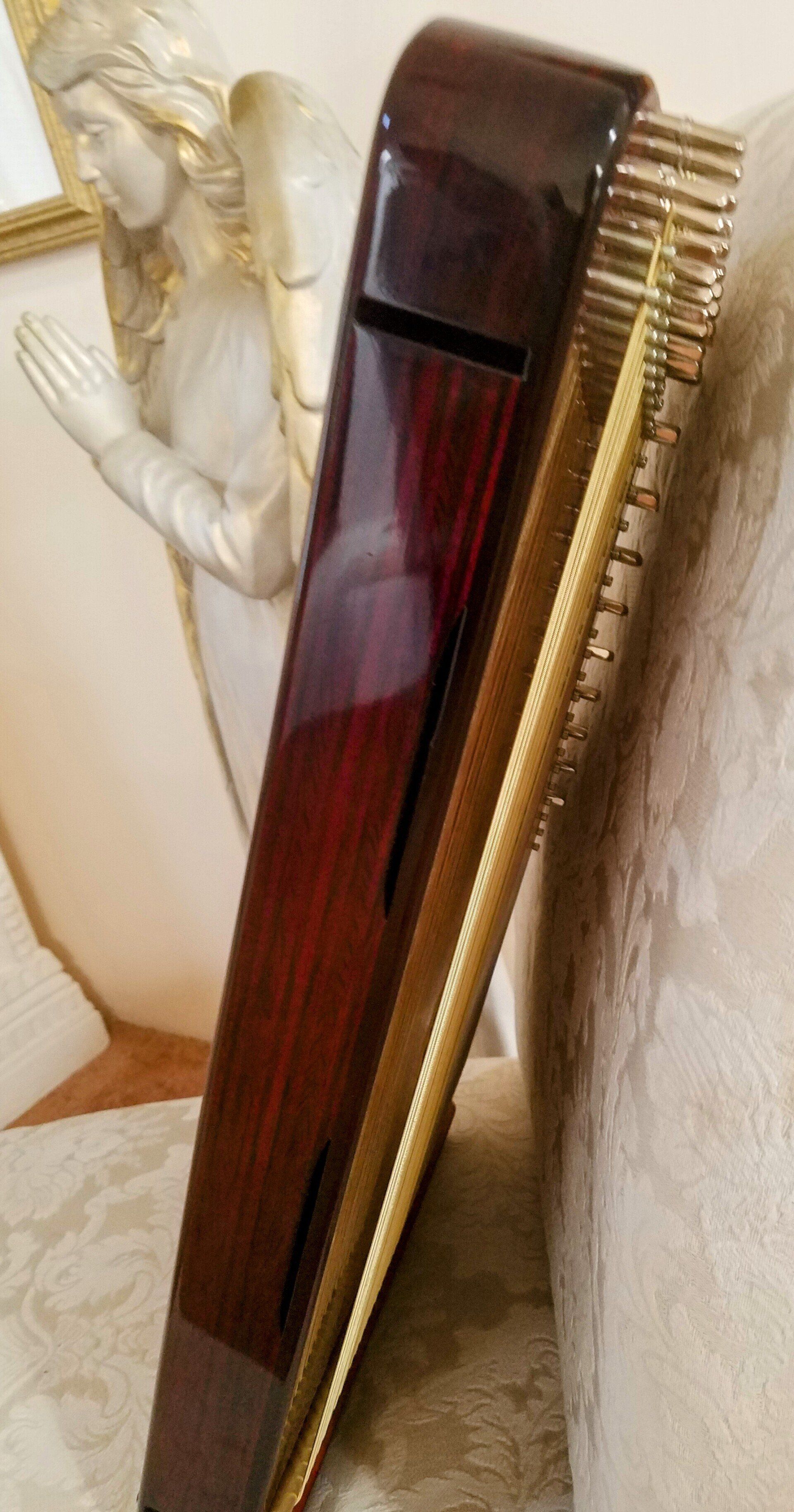 A harp is sitting on a couch next to a statue of an angel.