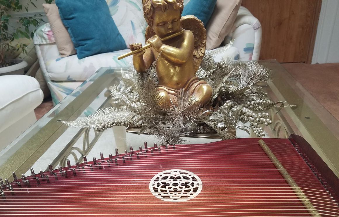 A table with a harp and a statue of an angel on it