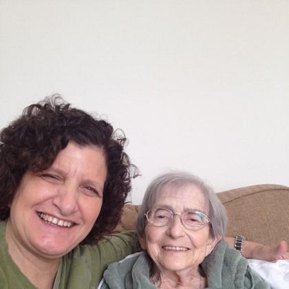 Two women are posing for a picture together and smiling.