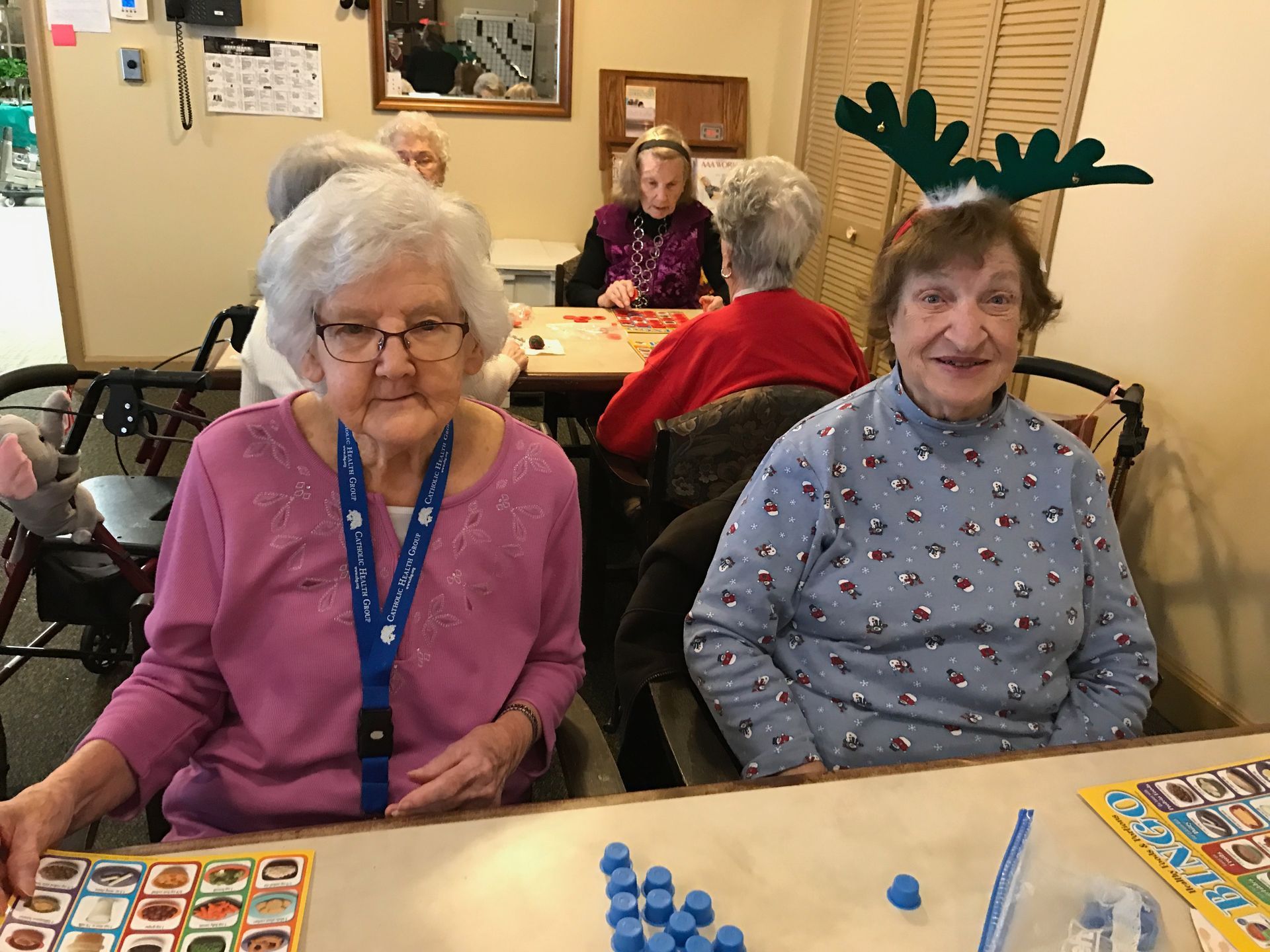 A group of elderly women are sitting at a table playing bingo.