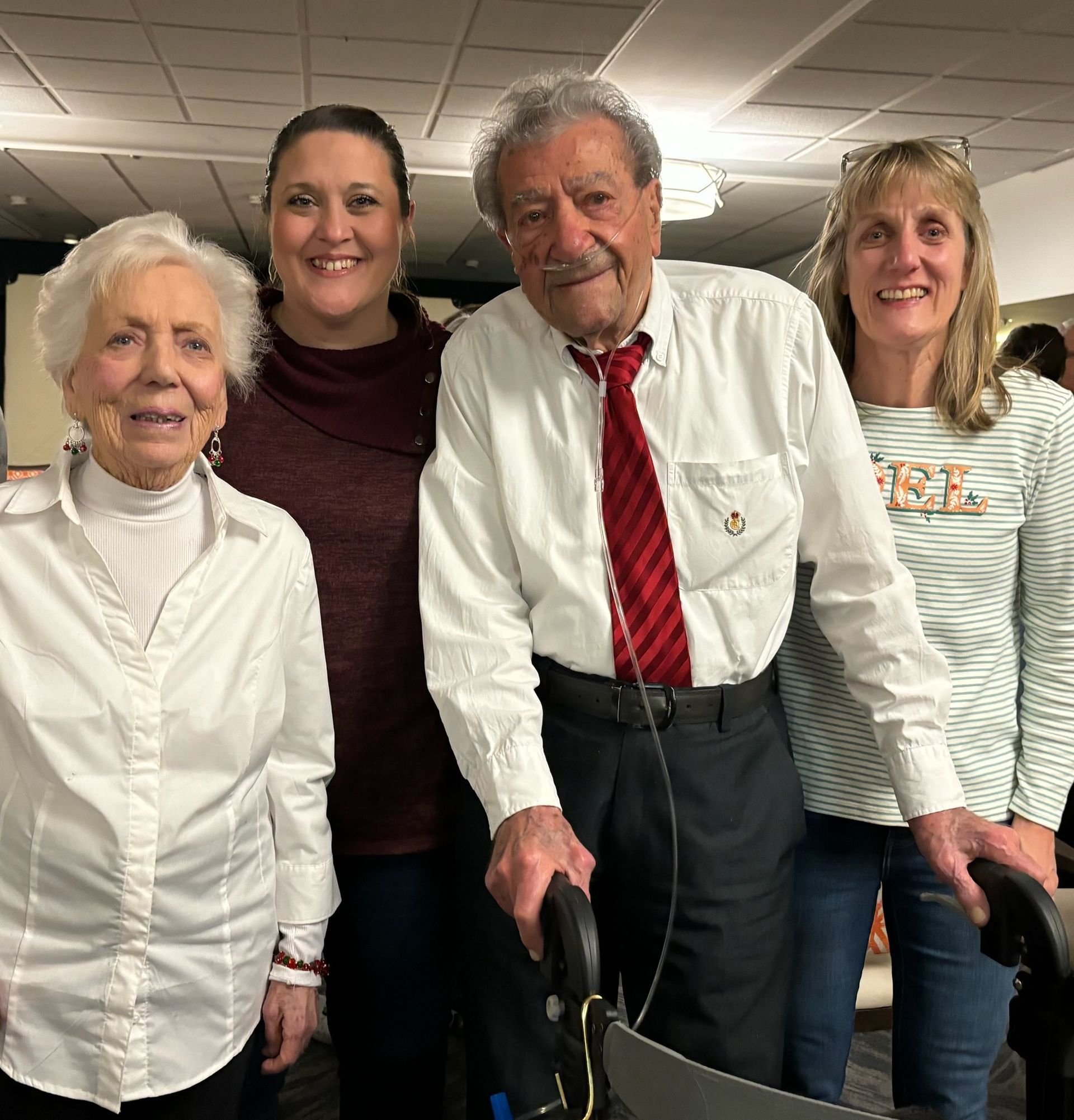 A group of people posing for a picture with one man holding a walker