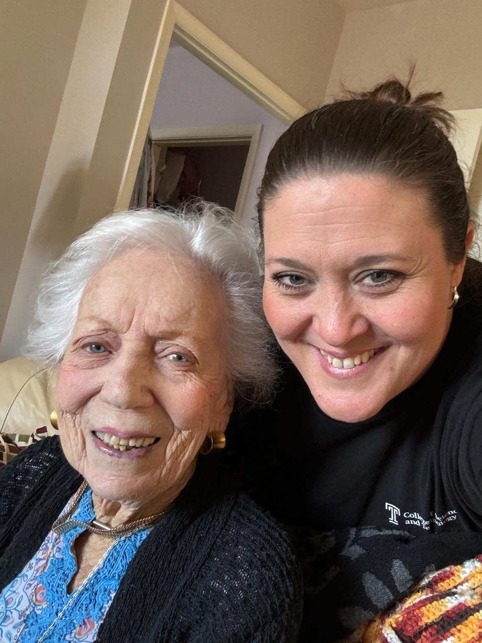 Two women are posing for a picture together and smiling.