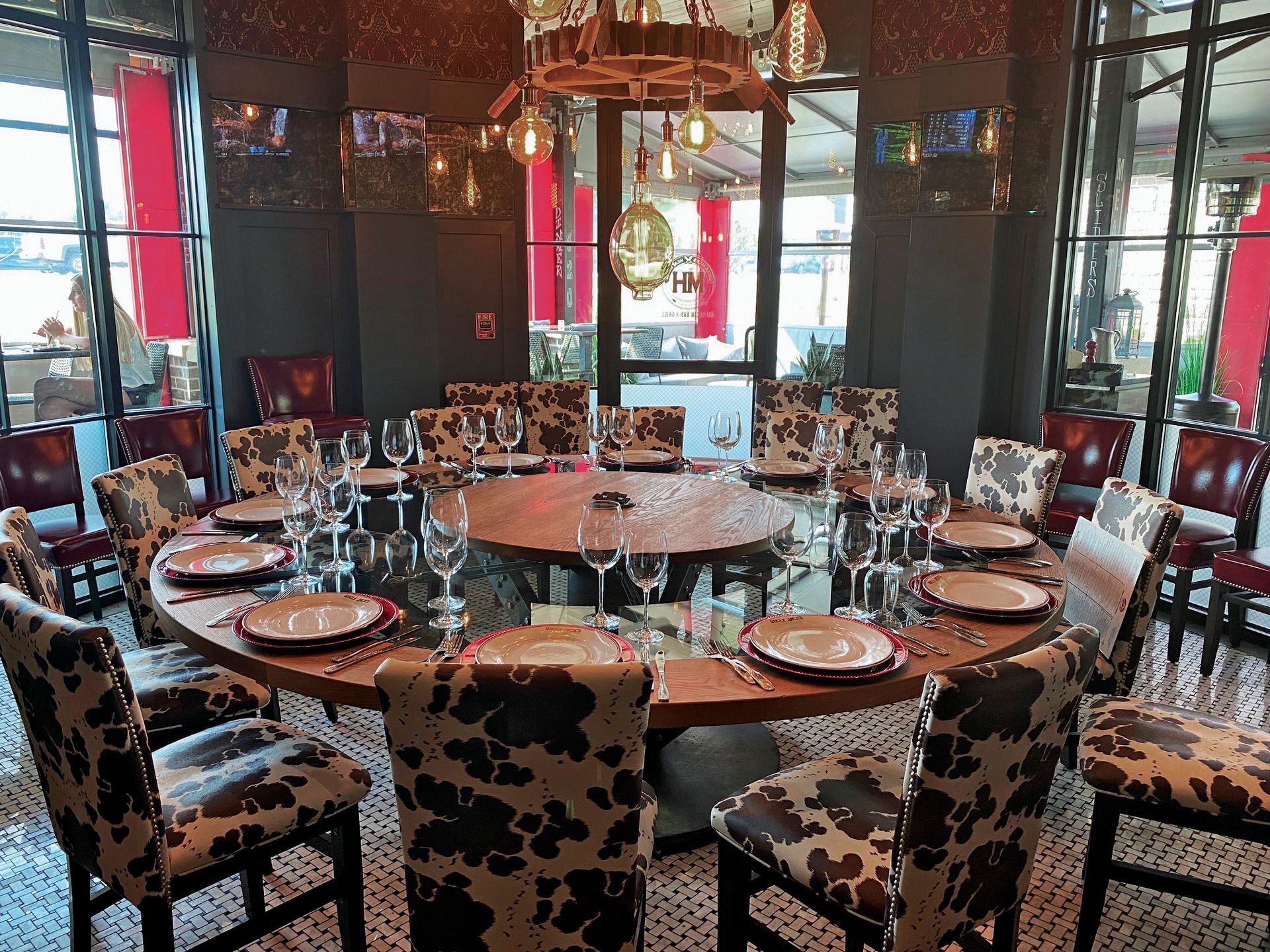 a dining room with a round table and cow print chairs, private dining at uncle jacks meathouse