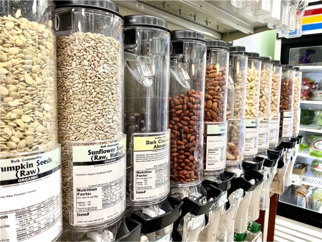 A Row of Containers Filled With Nuts and Seeds in a Grocery Store