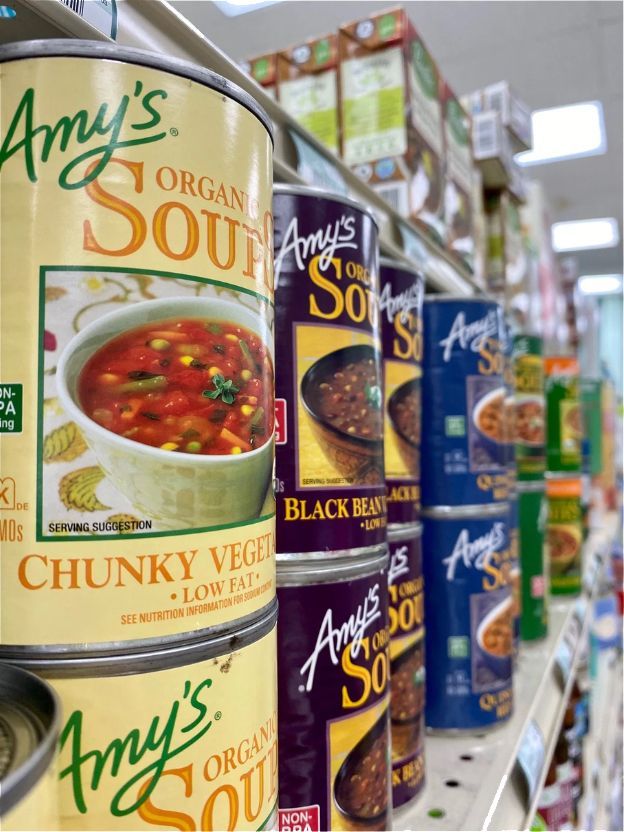Several Cans of Amy 's Soup Are Lined Up on a Shelf