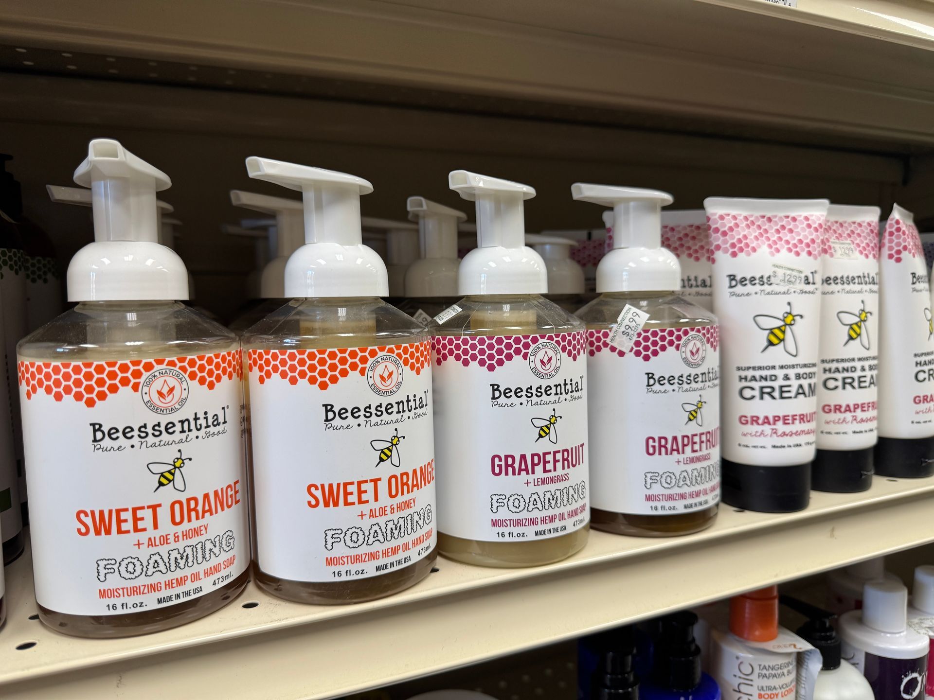 A shelf filled with bottles of foaming hand soap and lotion