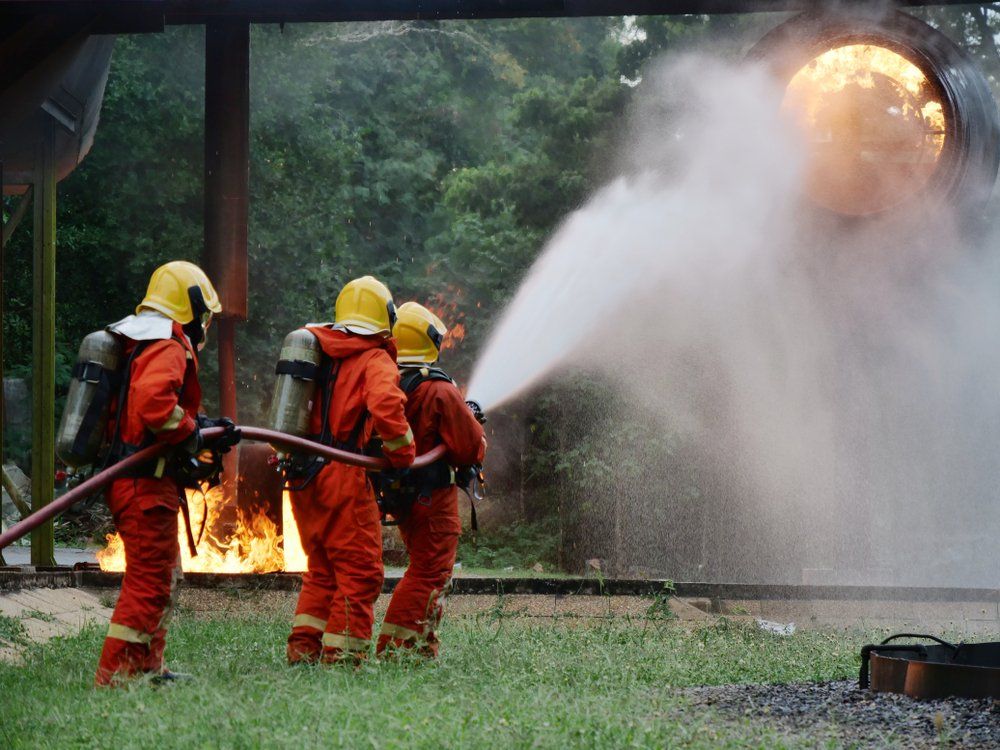 A Group of Firefighters Are Spraying Water on A Fire — Fire Protection Services in Mullumbimby, NSW