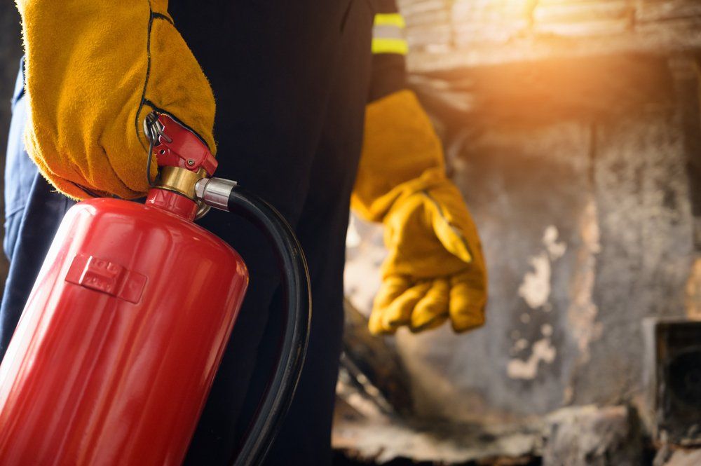 Fire Fighter Holding the Fire Extinguisher — Fire Protection Services in Goonellabah, NSW