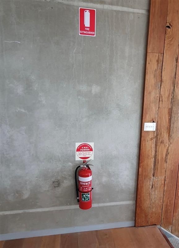 Professional Checking A Fire Extinguisher — Fire Protection Services in Goonellabah, NSW