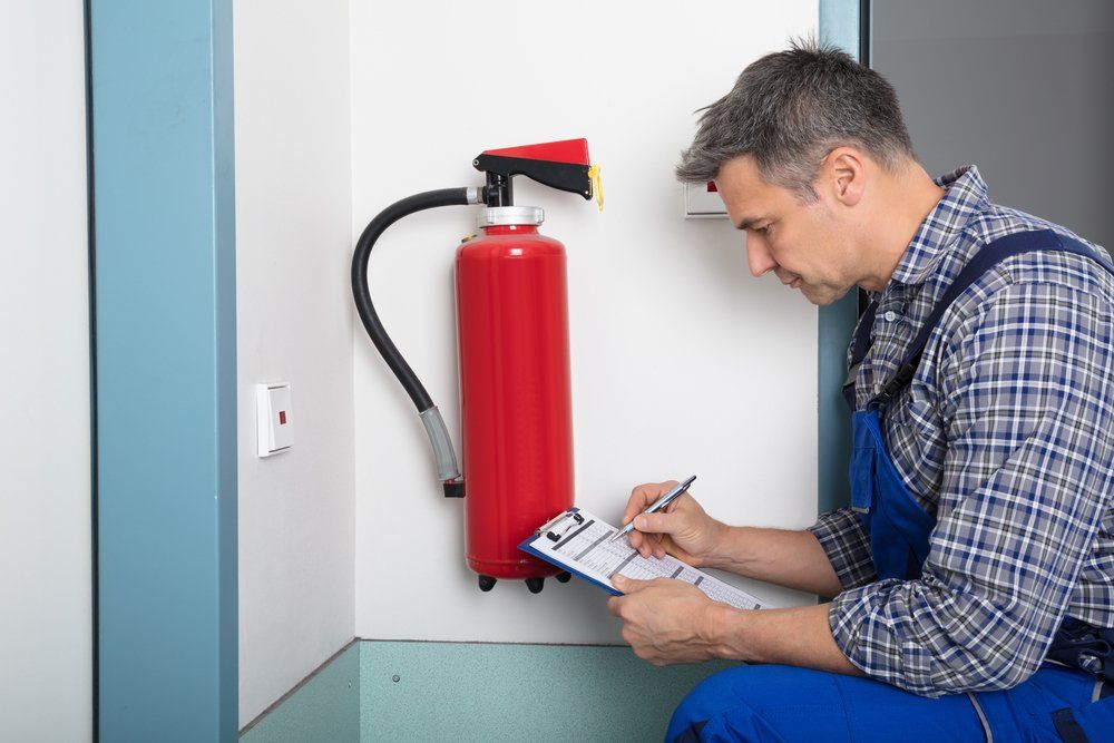 Professional Checking A Fire Extinguisher — Fire Protection Services in Goonellabah, NSW