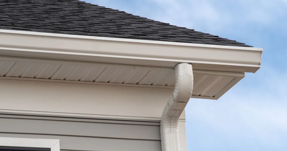 A close up of a gutter on the side of a house.