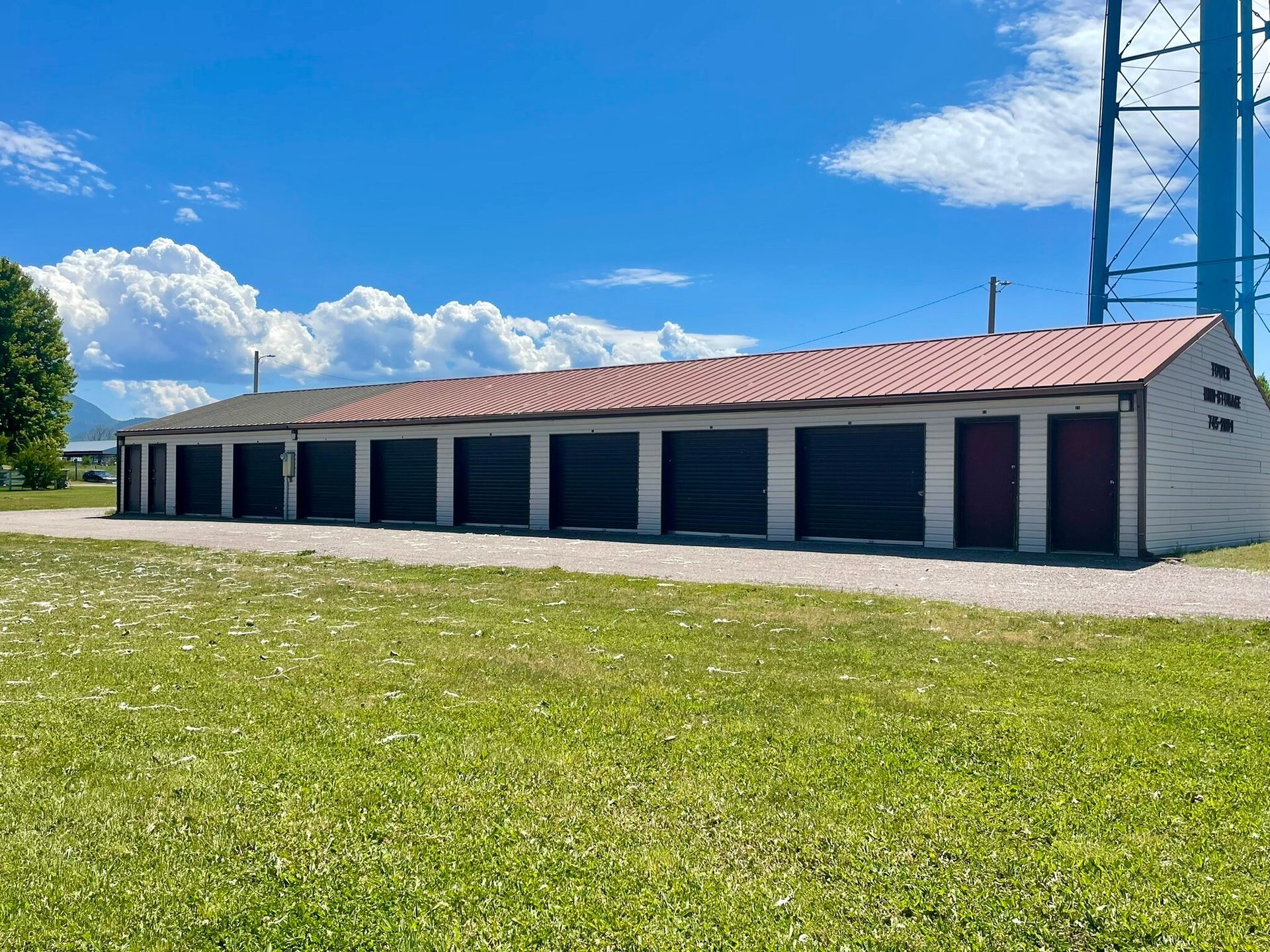 A row of garages are lined up in a grassy field.