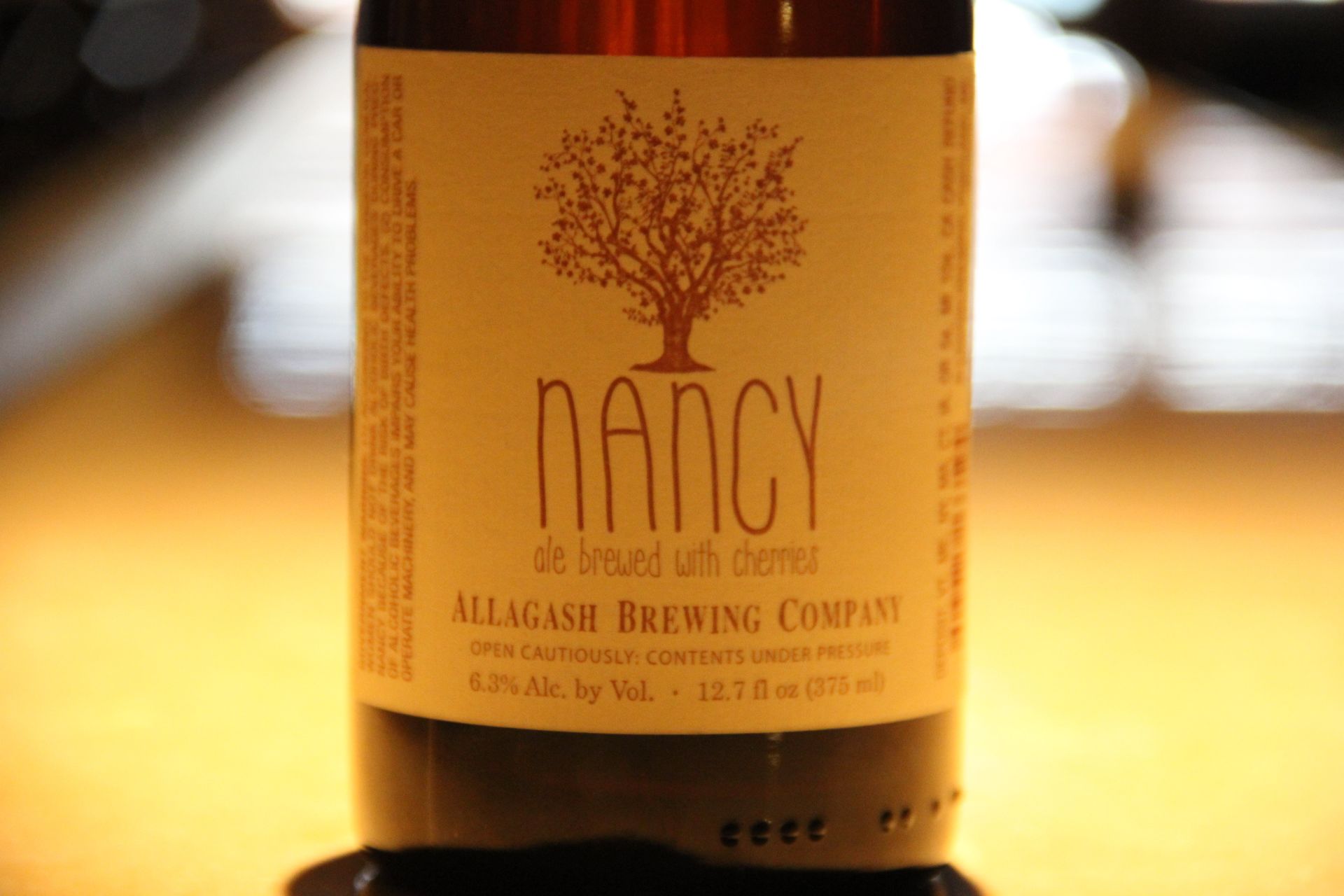 A bottle of nancy allagash brewing company sits on a table