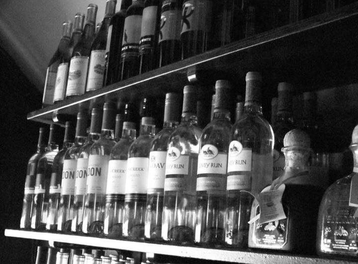 Several bottles of gin are lined up on a shelf