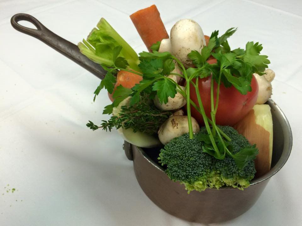 A pot filled with vegetables including broccoli carrots and mushrooms