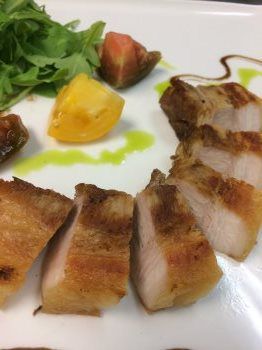 A white plate topped with sliced meat and vegetables.