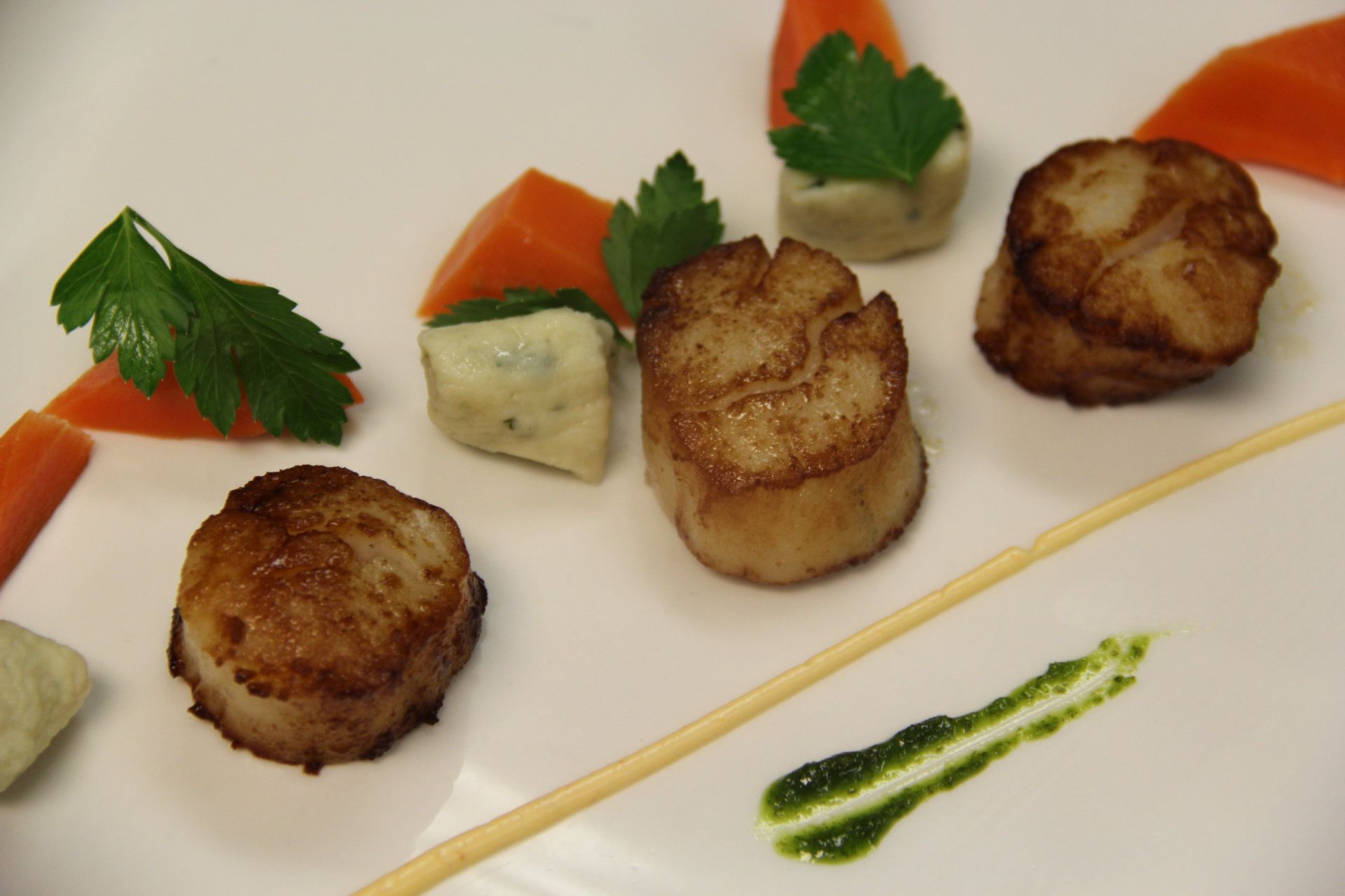 A plate of food with scallops and carrots on it