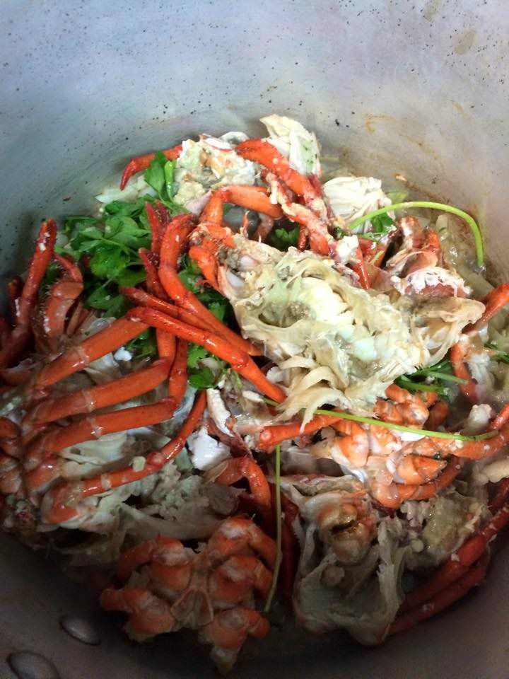 A close up of a pot filled with crabs and vegetables.