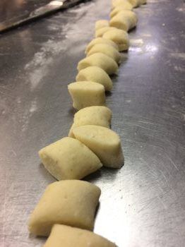 A row of dough cubes sitting on top of a metal surface.