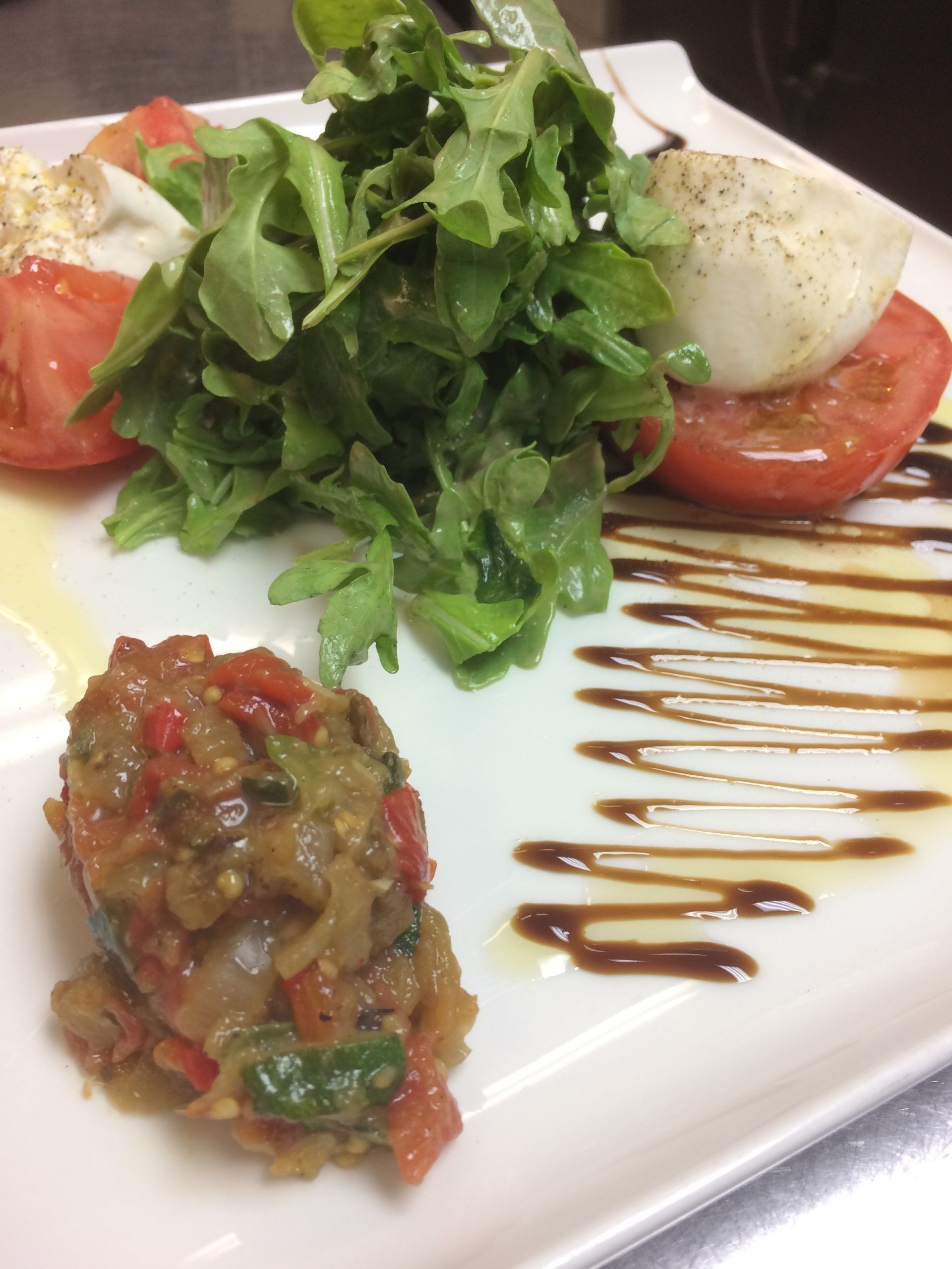 A white plate topped with a salad and tomatoes
