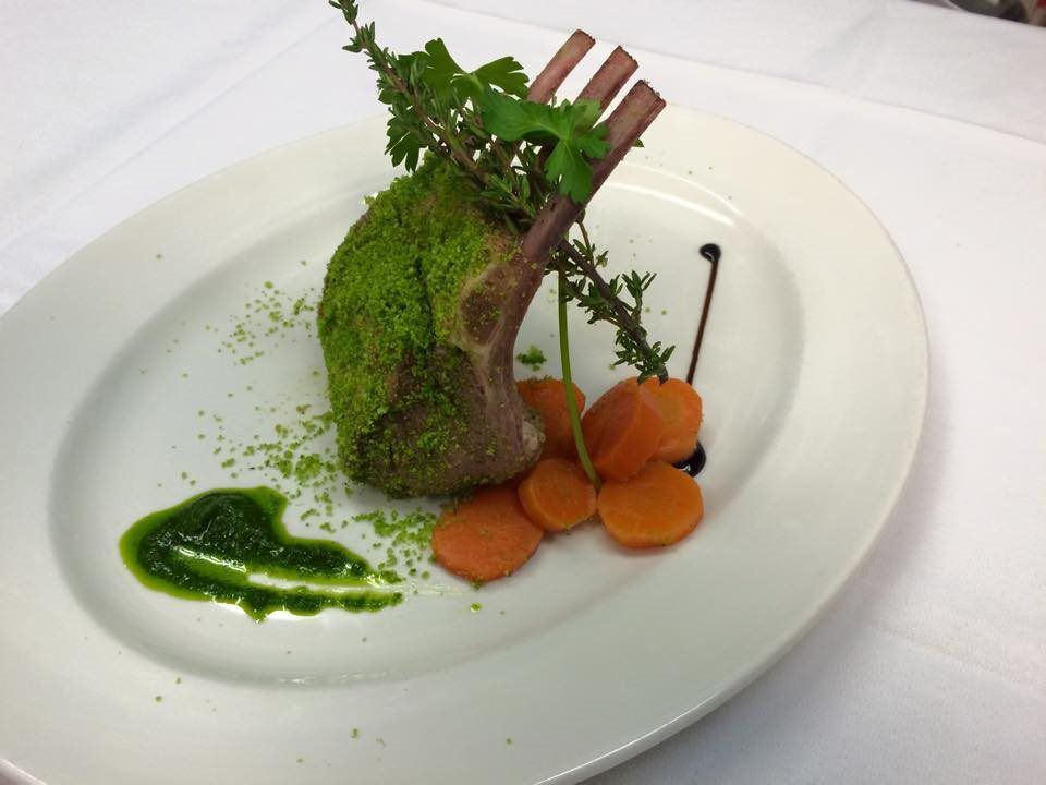 A white plate topped with a piece of meat and carrots