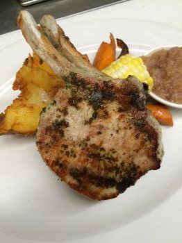 A white plate topped with a piece of meat and vegetables.