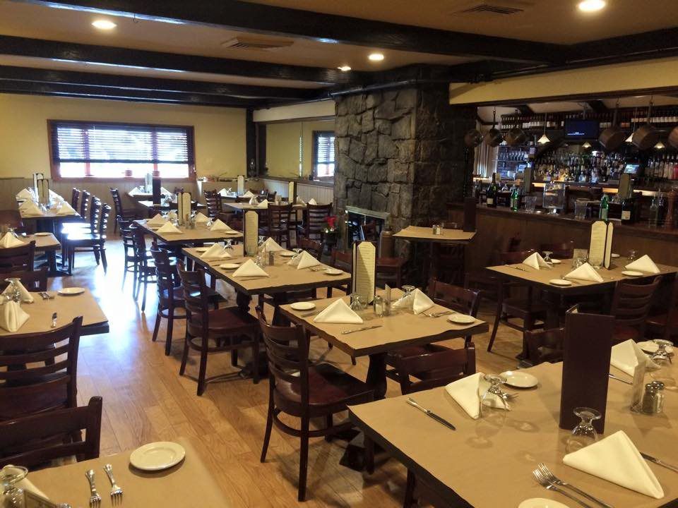 A restaurant with tables and chairs set up for dinner