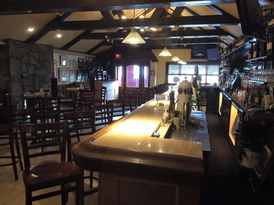 A restaurant with a long bar and chairs