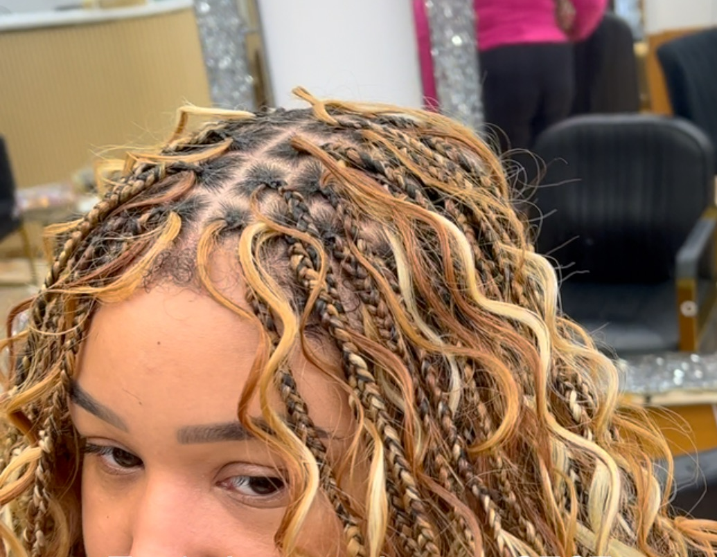 A close up of a woman 's hair with braids in a salon.