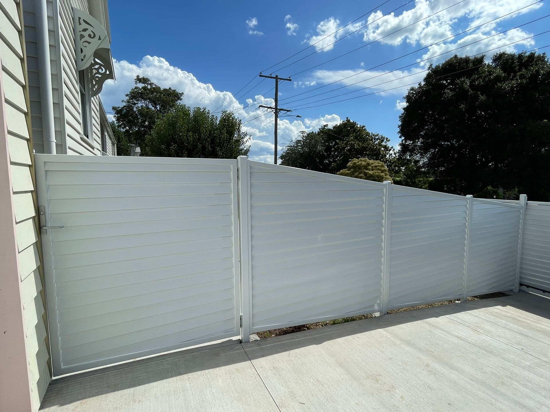 A white fence is sitting in front of a house.