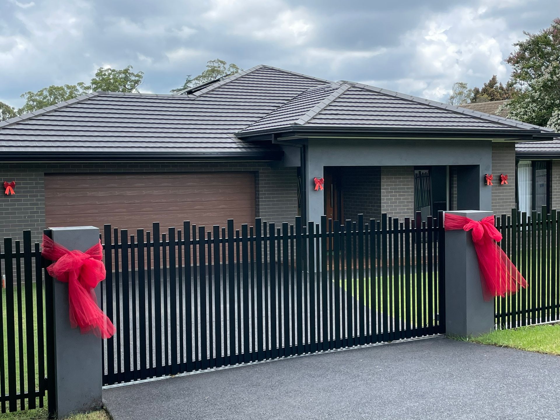 A house with a black fence and a red bow on it